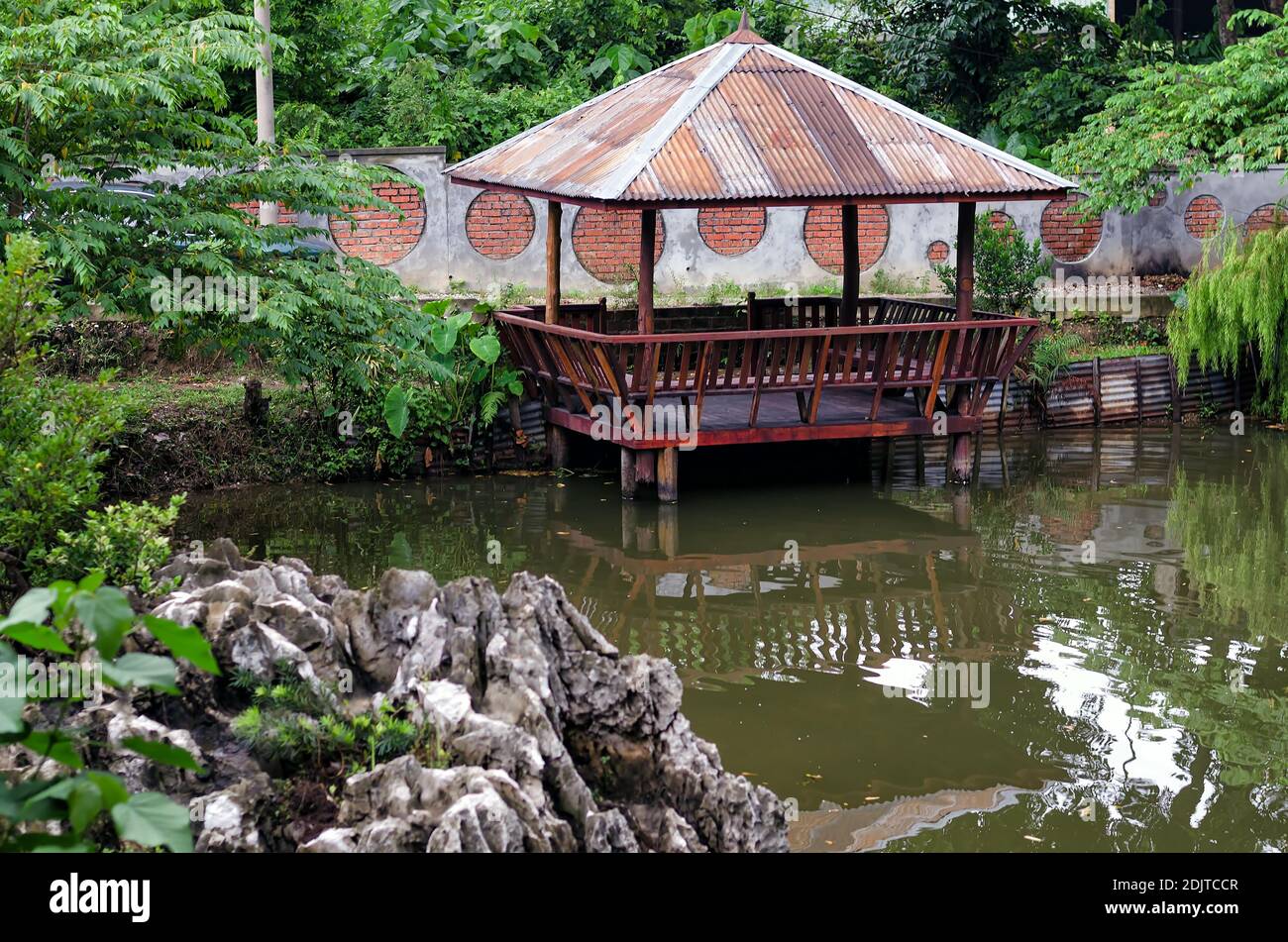 Old hut beside the pond - Small wooden hut on the shore of a pond. Stock Photo