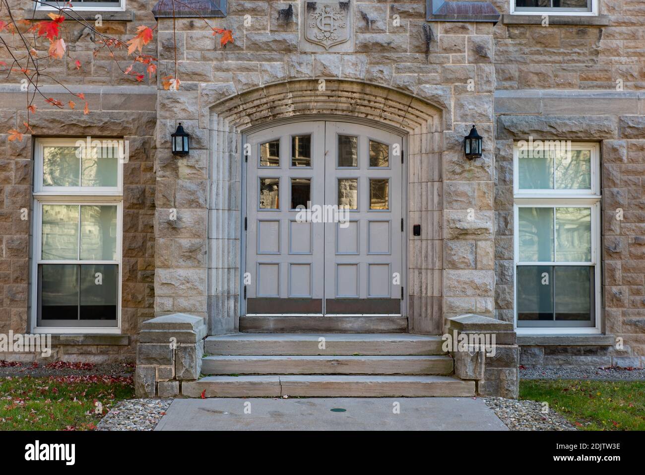 Front doors of a grey limestone building on Queen's university campus. Stock Photo