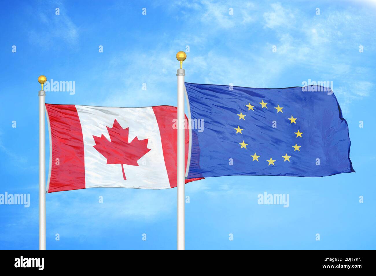Canada and European Union two flags on flagpoles and blue cloudy sky Stock Photo