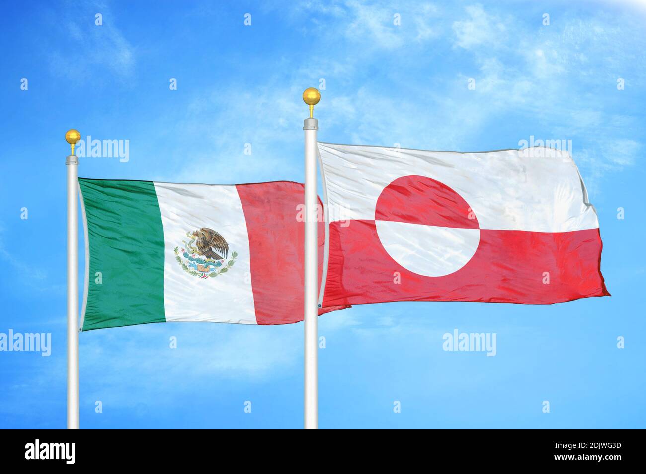 Mexico and Greenland two flags on flagpoles and blue cloudy sky Stock Photo