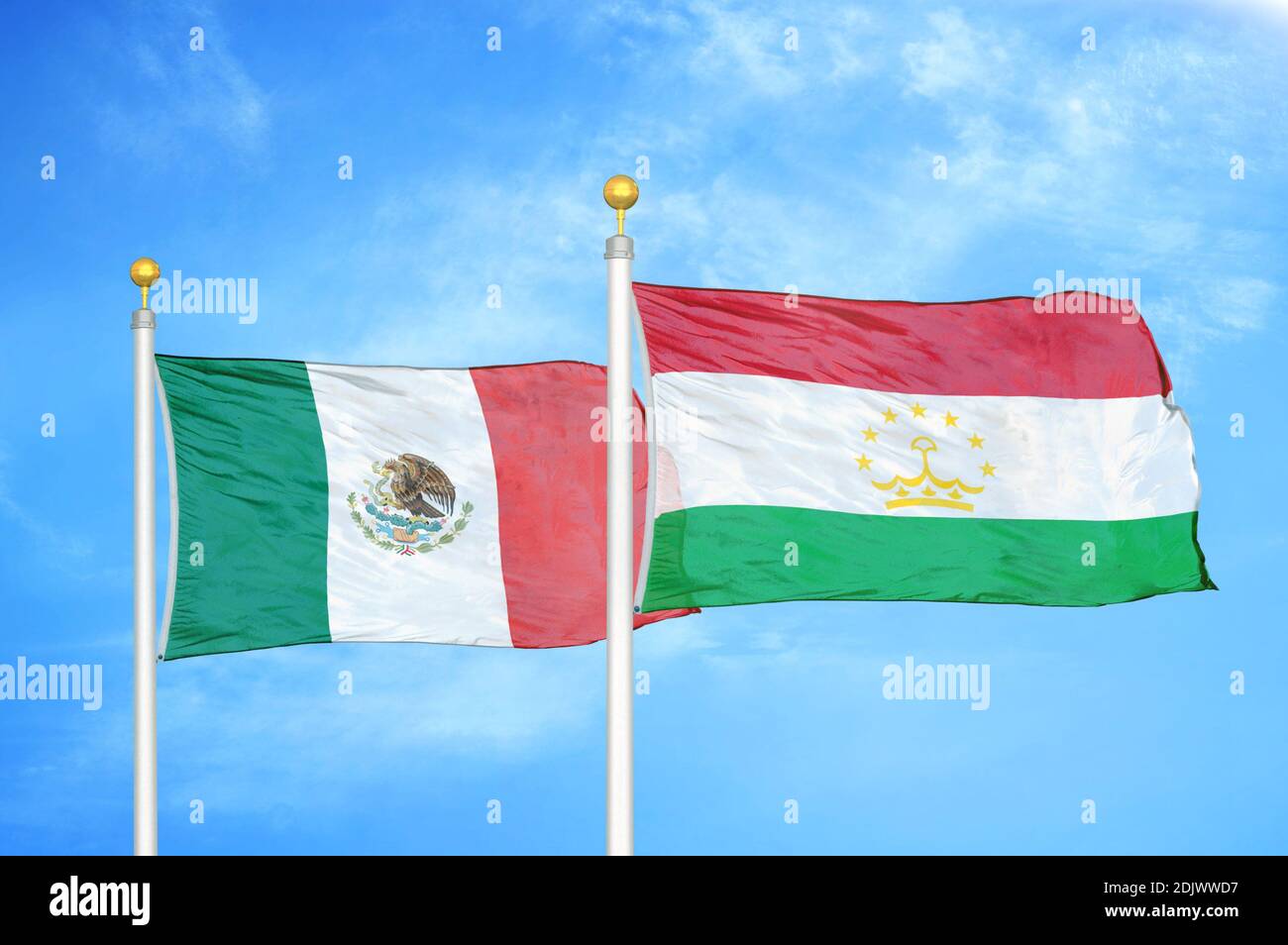 Mexico and Tajikistan two flags on flagpoles and blue cloudy sky Stock Photo