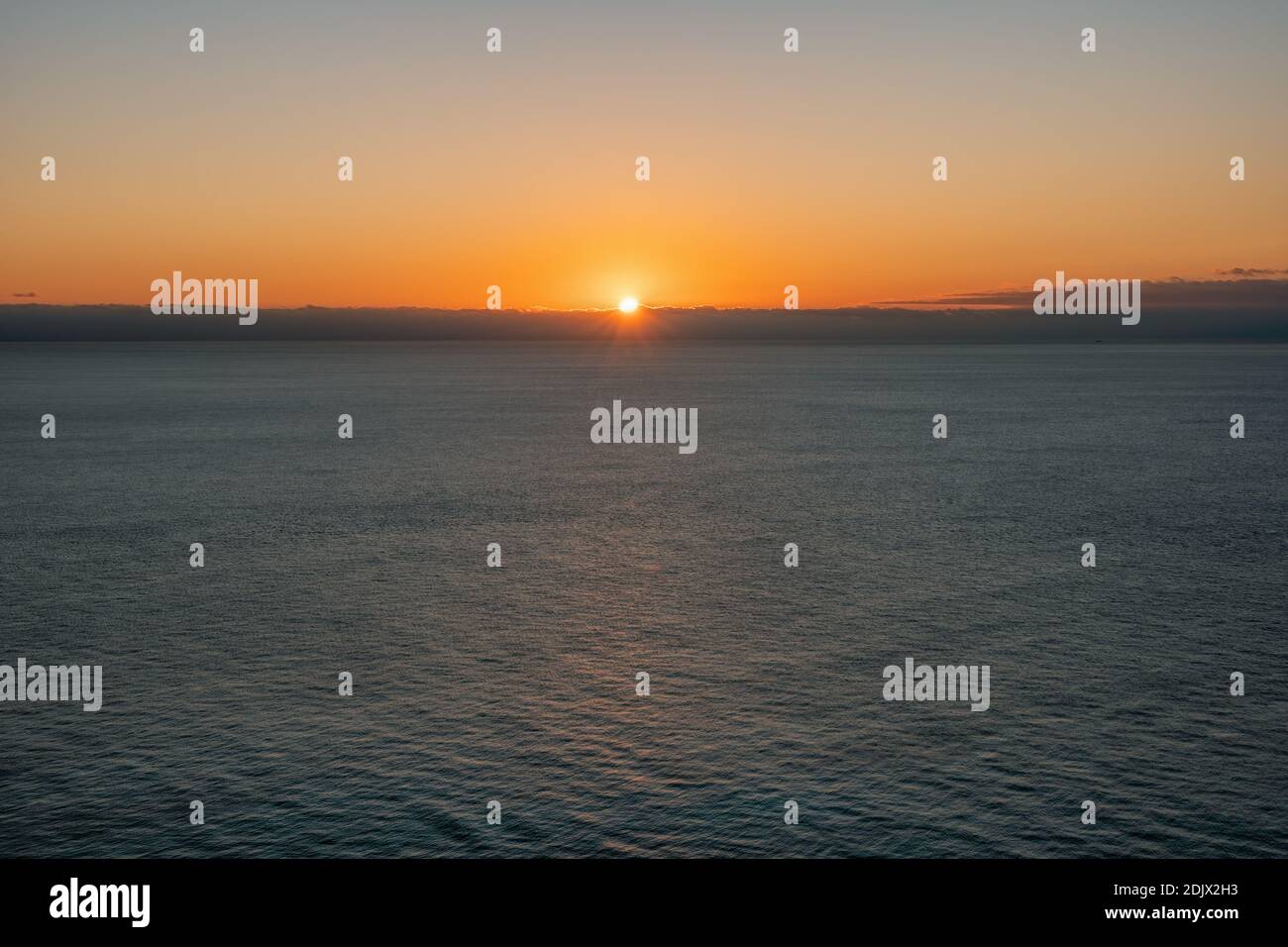 Abstract Aerial panoramic view on warm sunset over sea. Nothing but sky, clouds and water. The concept of calmness silence and unity with nature. Stock Photo