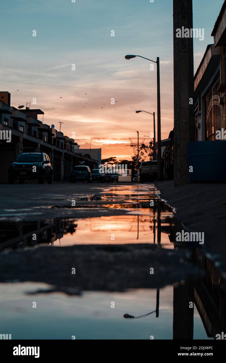 Cars On Street By City Against Sky During Sunset. Un Gran Y Hermoso Atardecer Stock Photo
