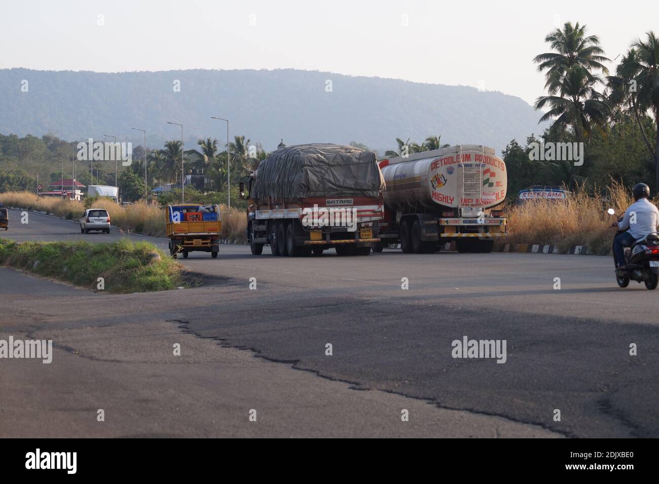 Thrissur, Kerala, India - 11-28-2020: Loaded vehicles passing through the national highway. Truck, Tanker and Auto rickshaw Stock Photo