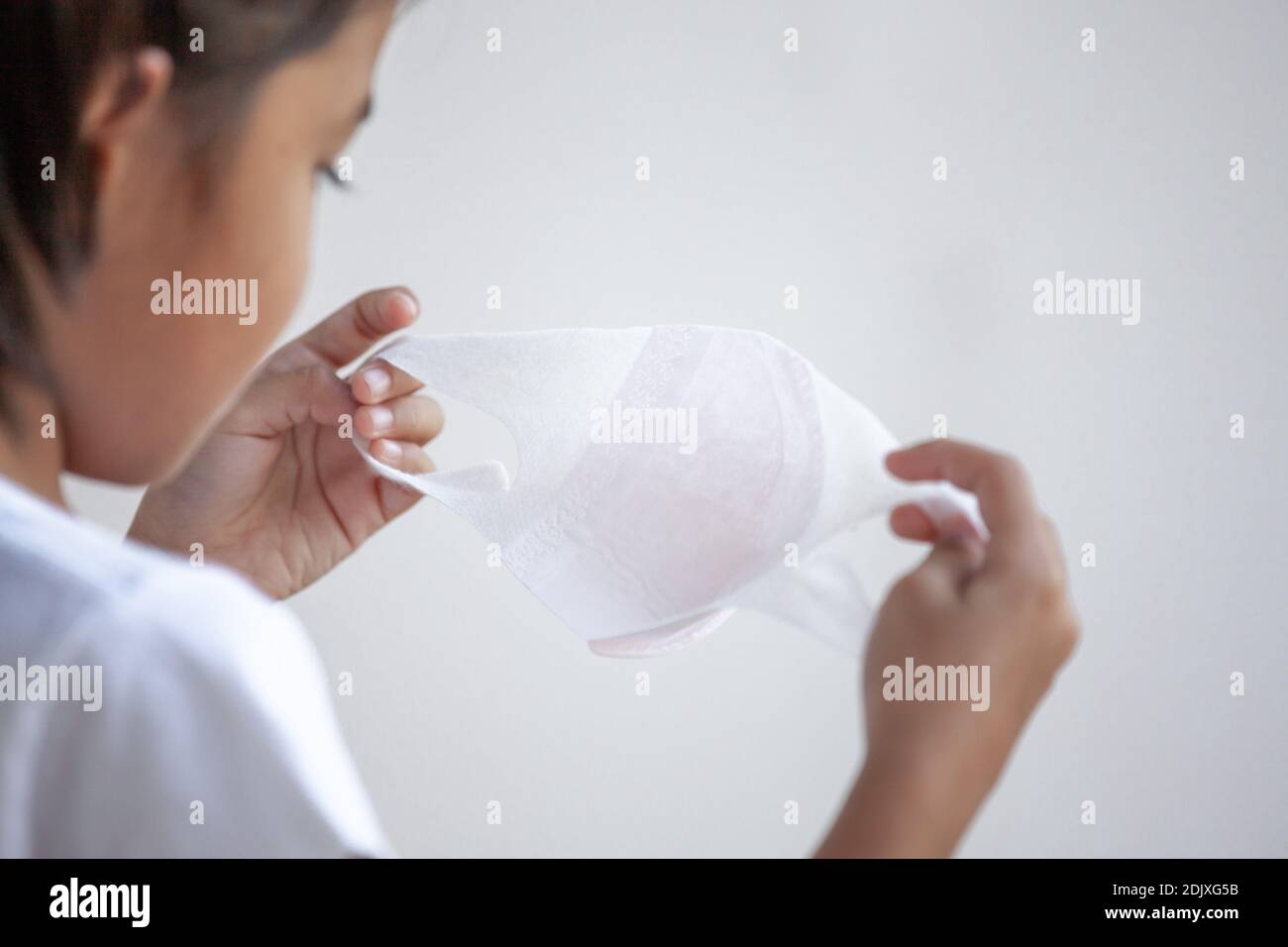 Closeup Of Girl Holding Mask Against White Background Stock Photo Alamy