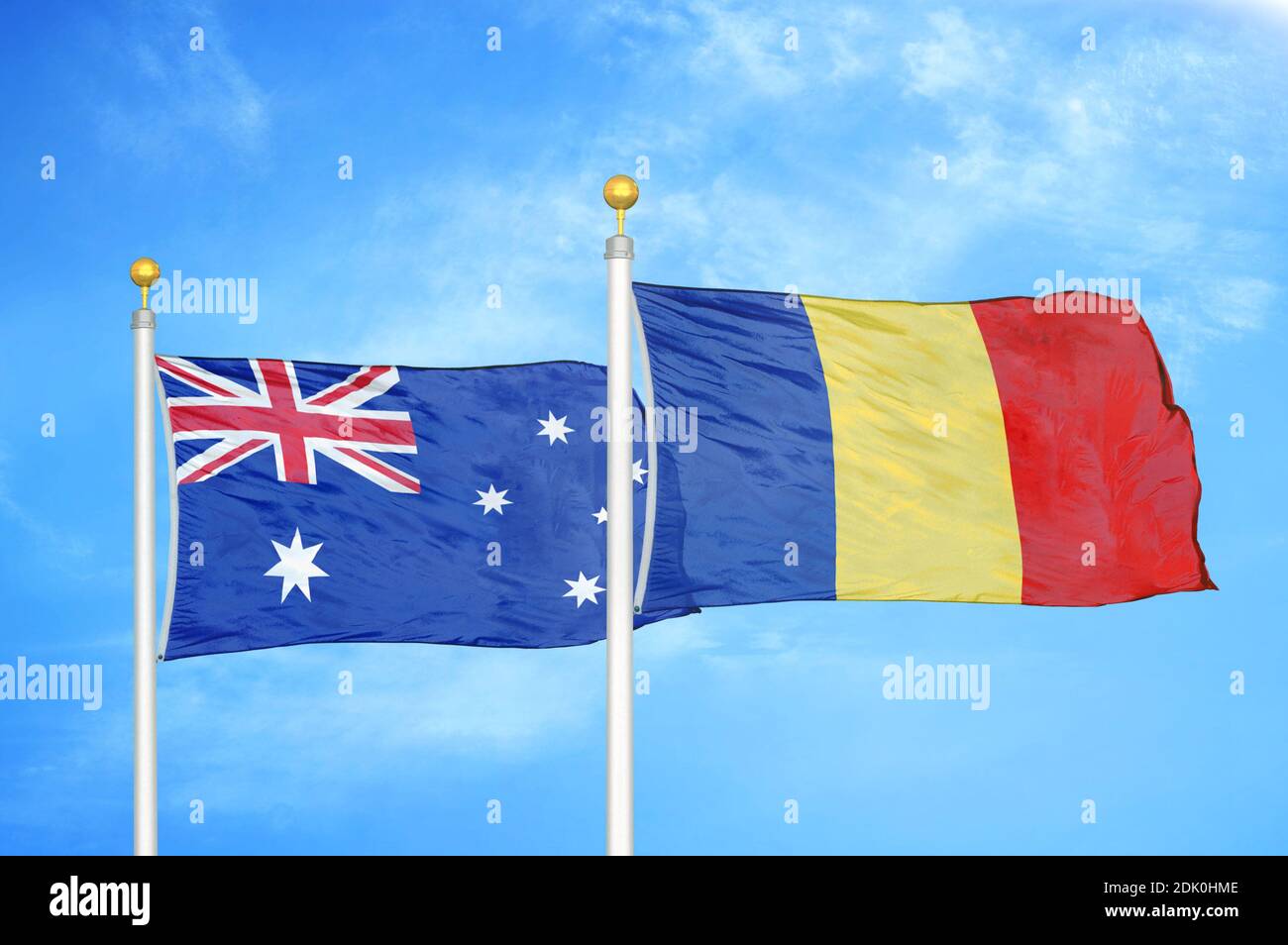 Australia and Romania two flags on flagpoles and blue cloudy sky Stock Photo