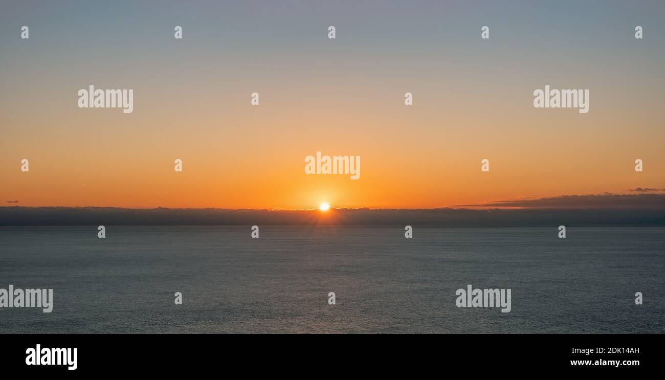 Abstract Aerial panoramic view on warm sunset over sea. Nothing but sky, clouds and water. The