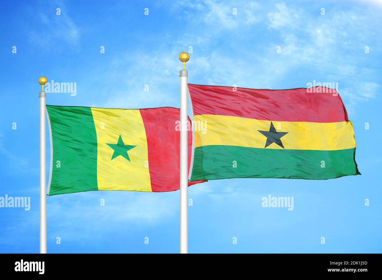 Senegal and Ghana two flags on flagpoles and blue cloudy sky Stock Photo
