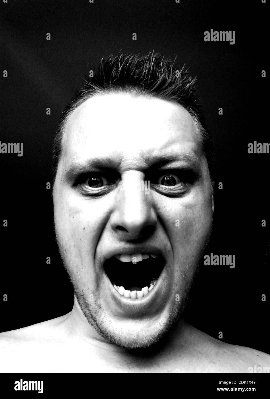 Close-up Portrait Of Angry Man Screaming In Darkroom Stock Photo - Alamy