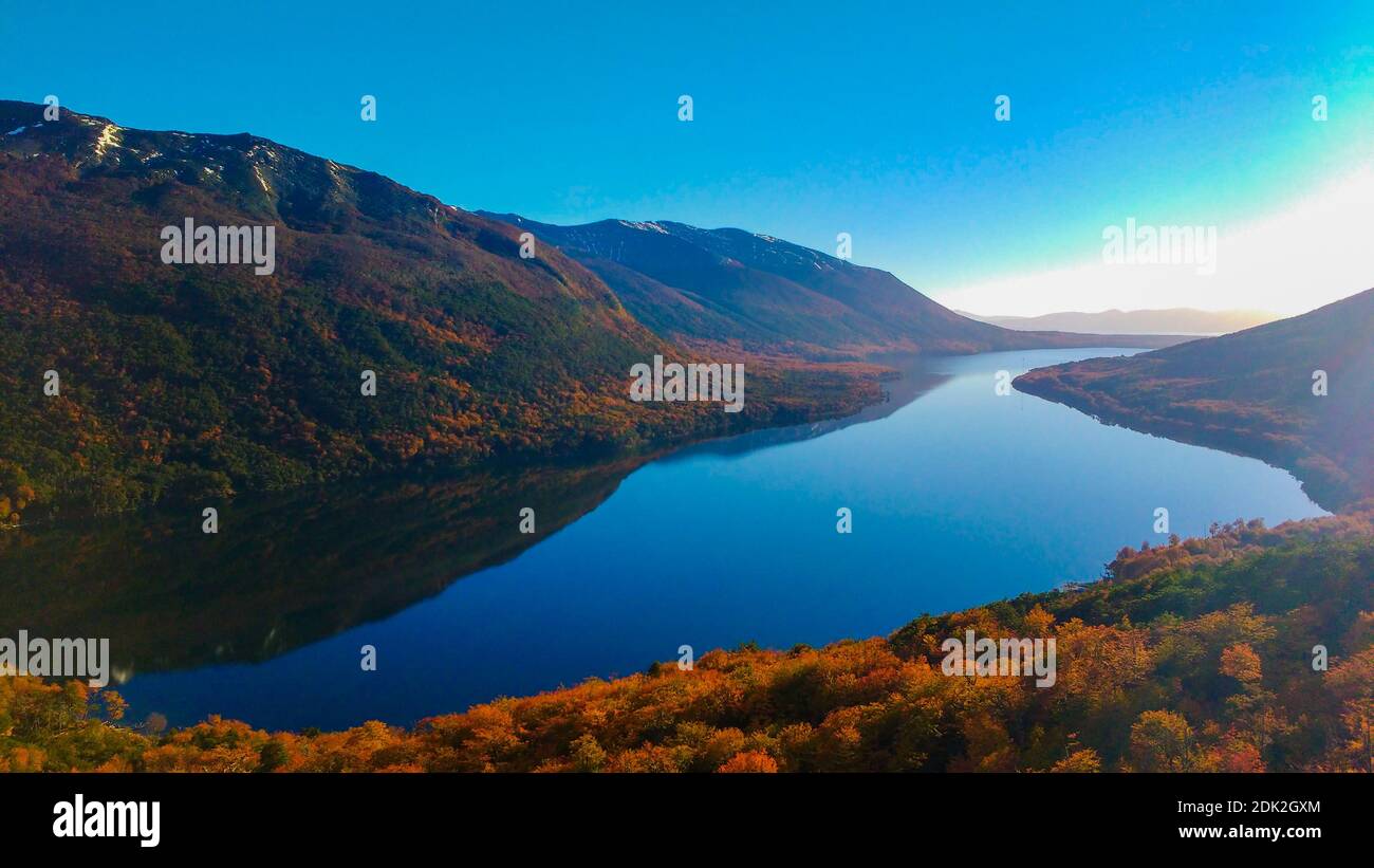 Scenic View Of Lake And Mountains Against Blue Sky Stock Photo