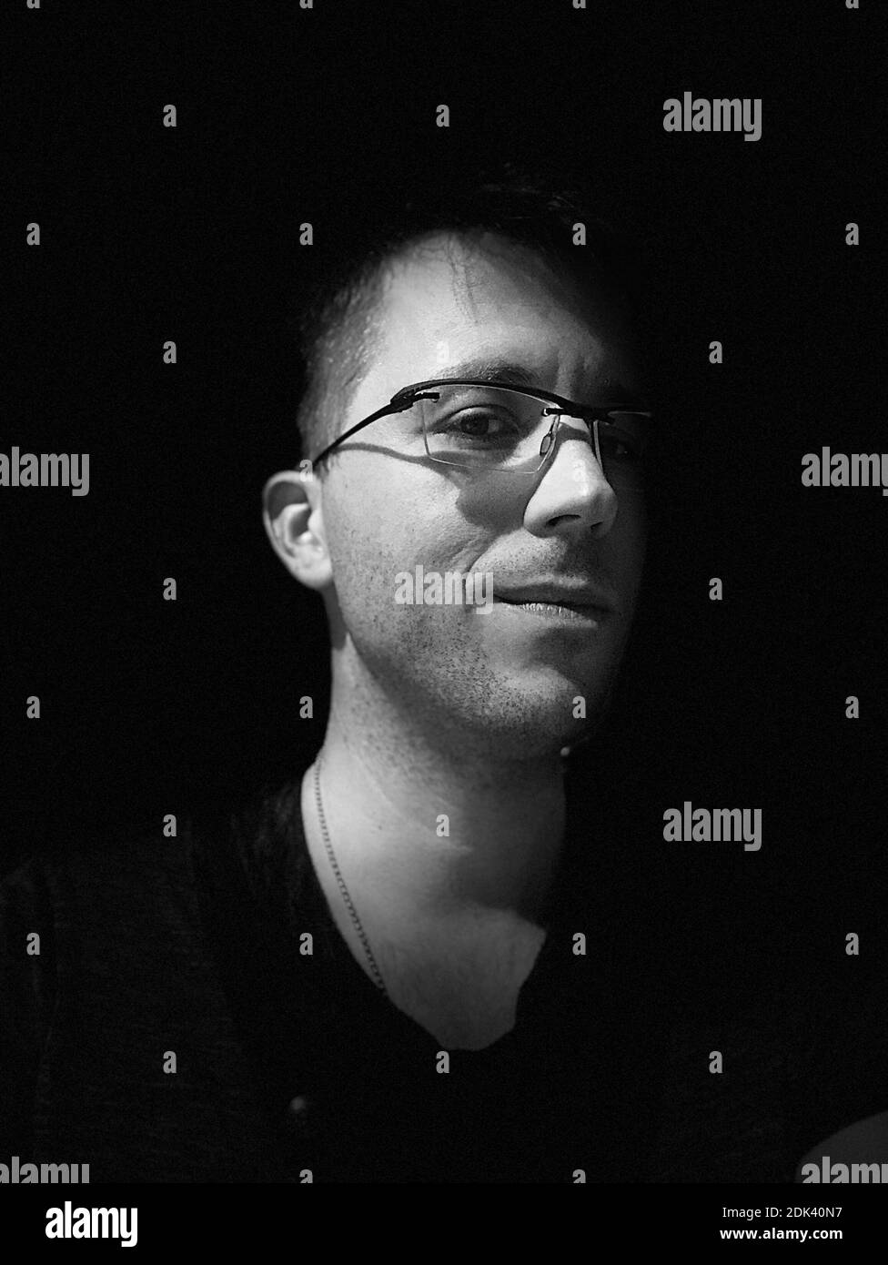 Portrait Of Mid Adult Man Wearing Eyeglasses Against Black Background Stock Photo