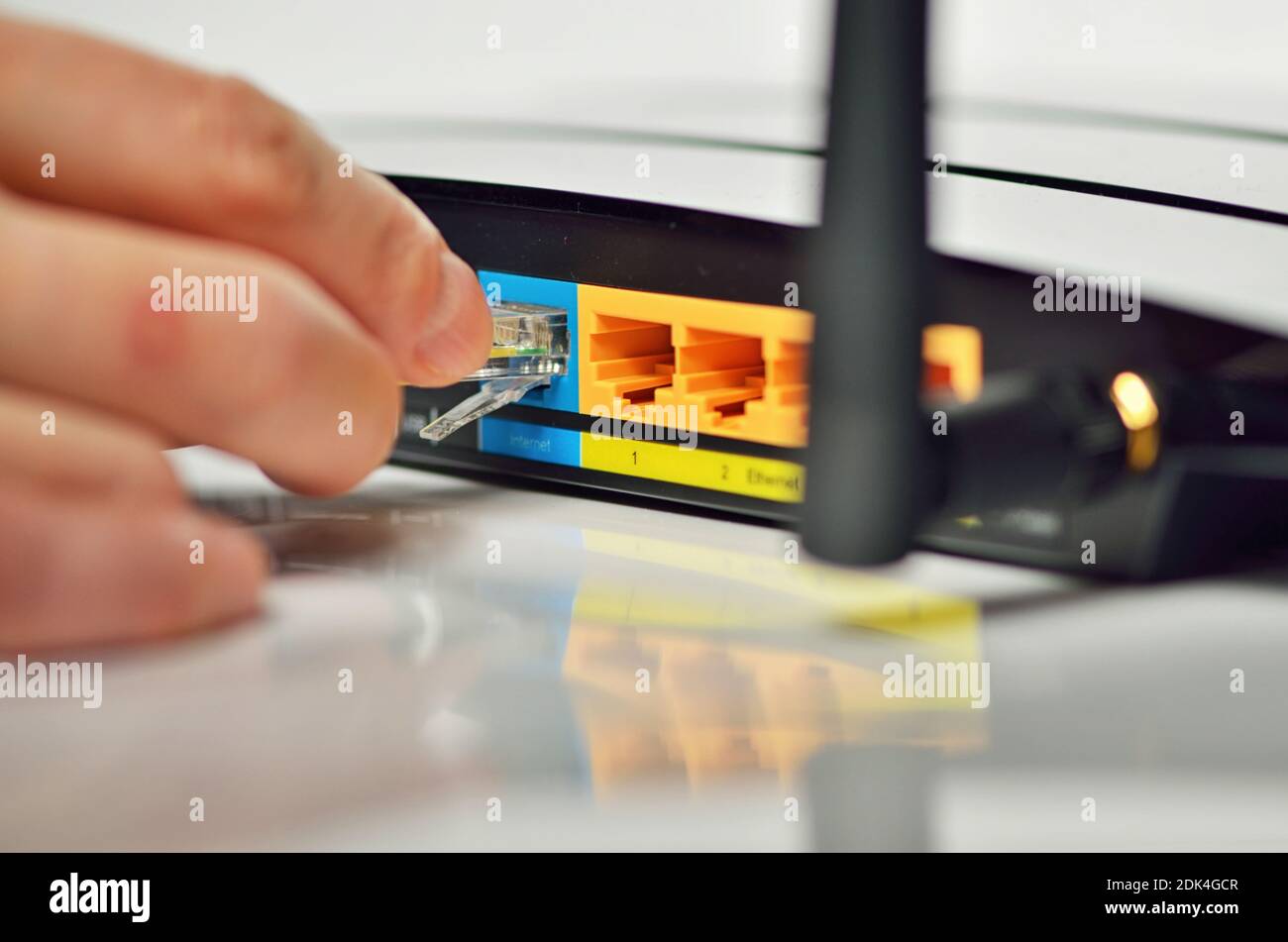 Cropped Hand Of Person Adjusting Wireless Router And Cable Stock Photo -  Alamy