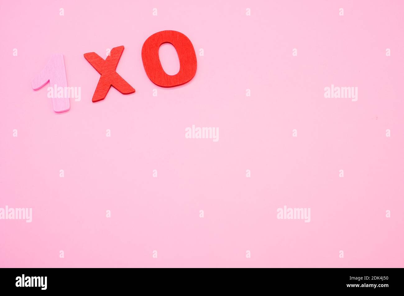 A top view of 1x0 written with wooden numbers on a pink surface Stock ...