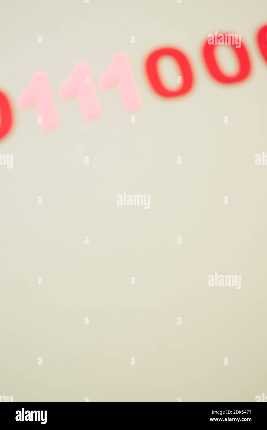 A vertical of blurry red and pink binary codes on a white surface Stock Photo