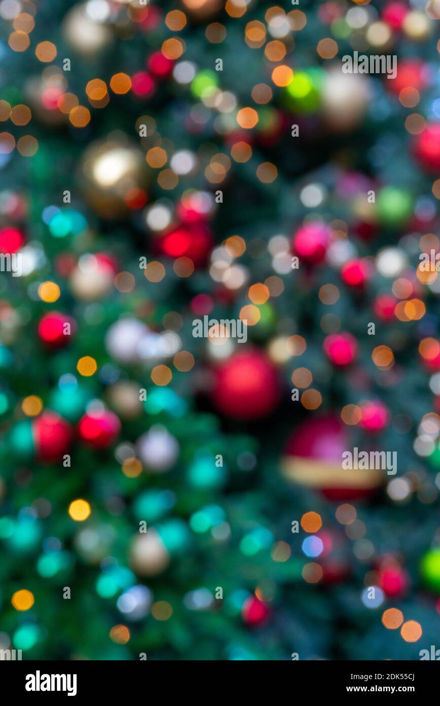 A vertical shot of a blurred bright festive Christmas tree background ...