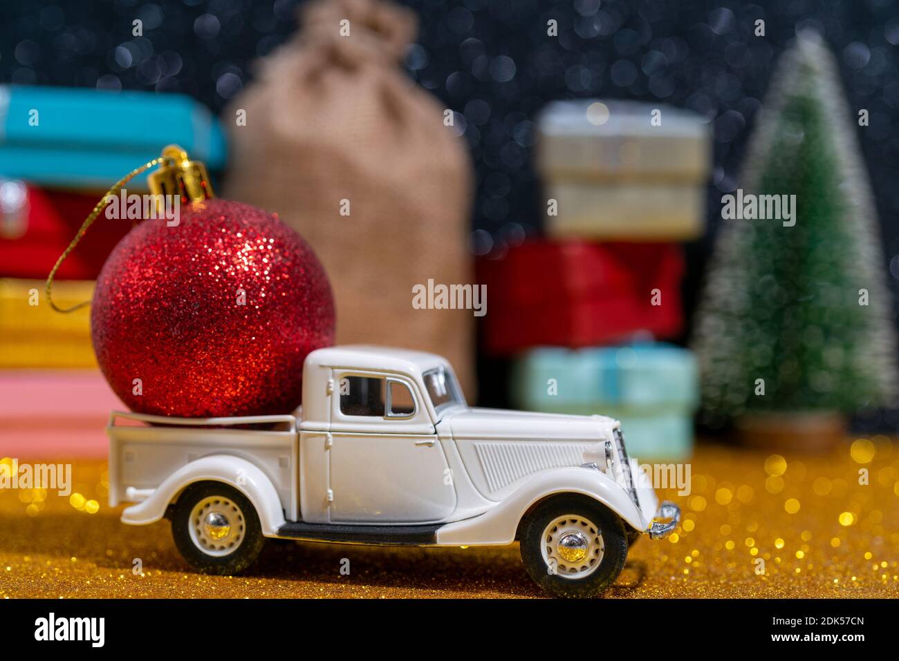 A small toy car delivery of Christmas gifts. Beautiful festive Christmas composition of gifts and toys Stock Photo