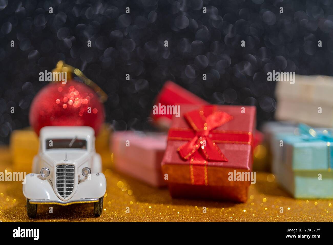 A small toy car delivery of Christmas gifts. Beautiful festive Christmas composition of gifts and toys Stock Photo