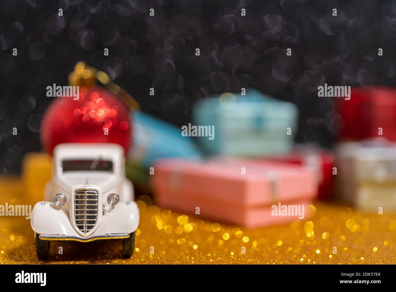 A small toy car delivery of Christmas gifts. Beautiful festive Christmas composition of gifts and toys Stock Photo