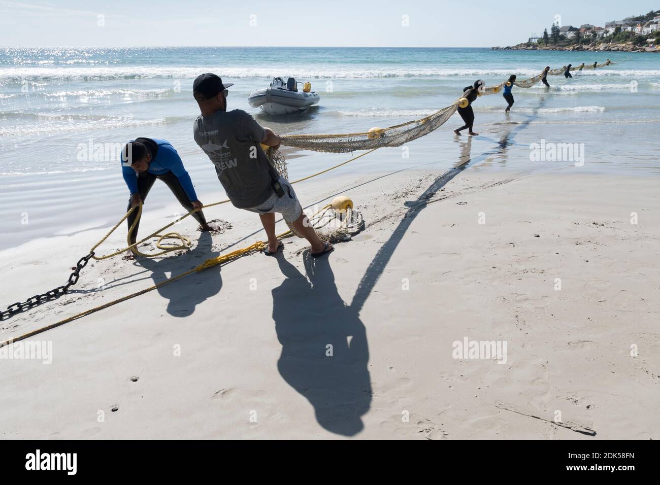 A Shark Spotters crew deploys a net shark exclusion barrier at Fish Hoek Beach, False Bay, Cape Town, South Africa. Bather protection. Tourism. Stock Photo