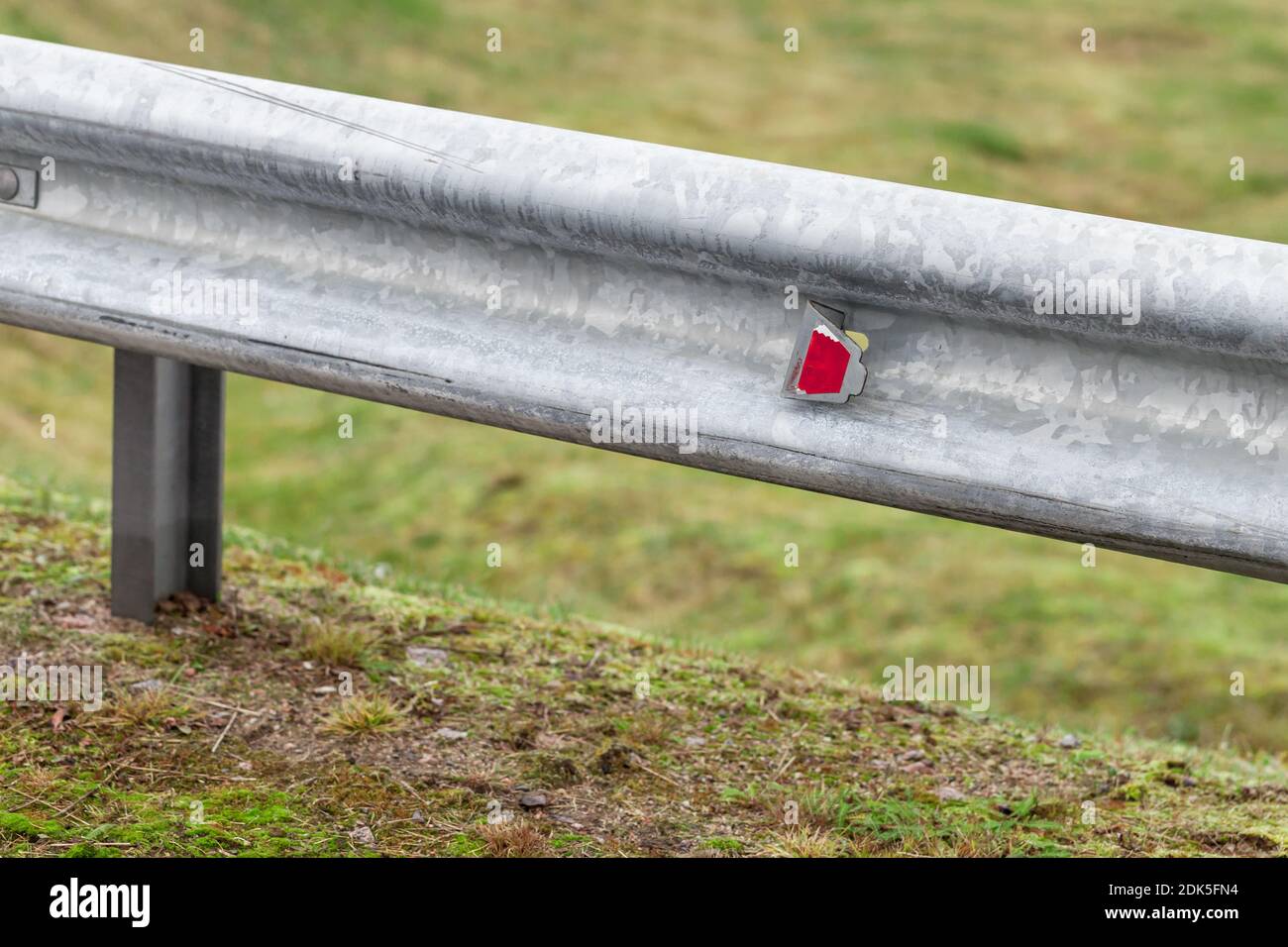 Retroreflector, warning optical unit is on a metal guardrail. Highway safety equipment, close-up Stock Photo