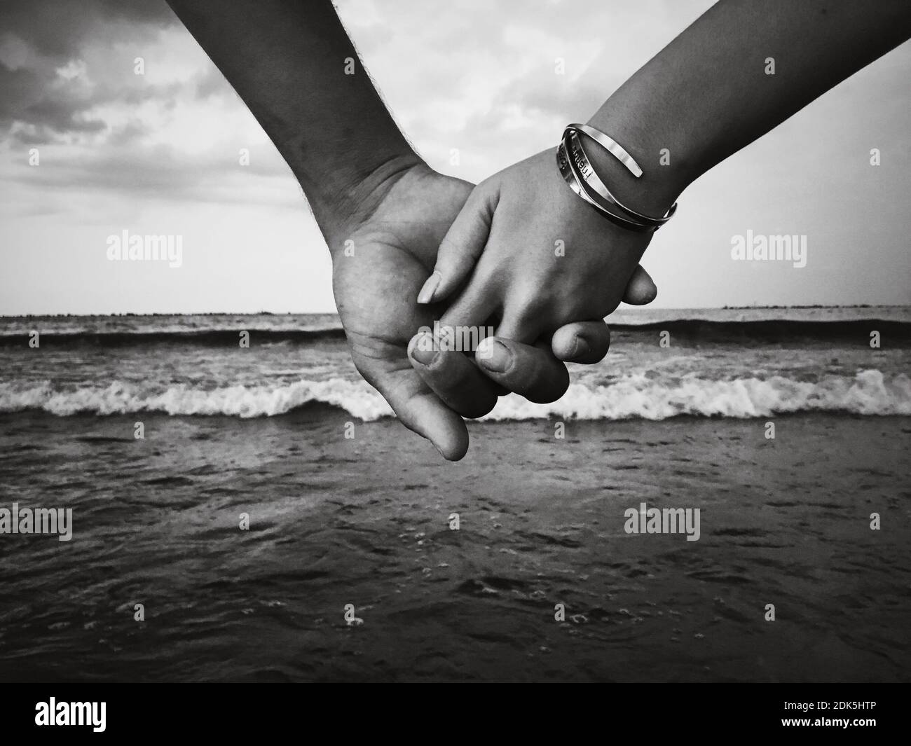 Close-up Of Hands Holding Sea Against Sky Grayscale Stock Photo