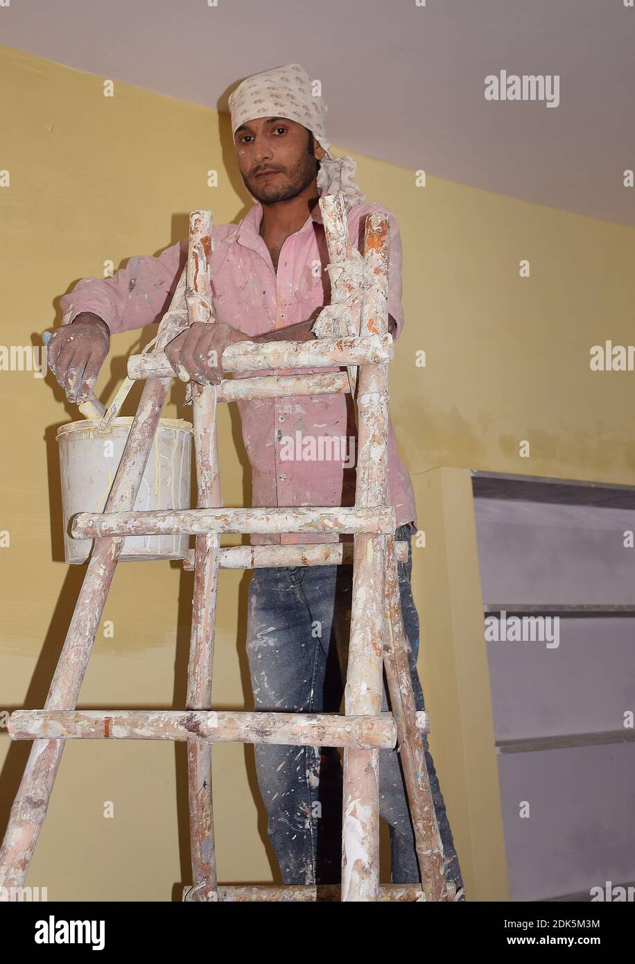 An Indian painter or construction worker looking at the camera while