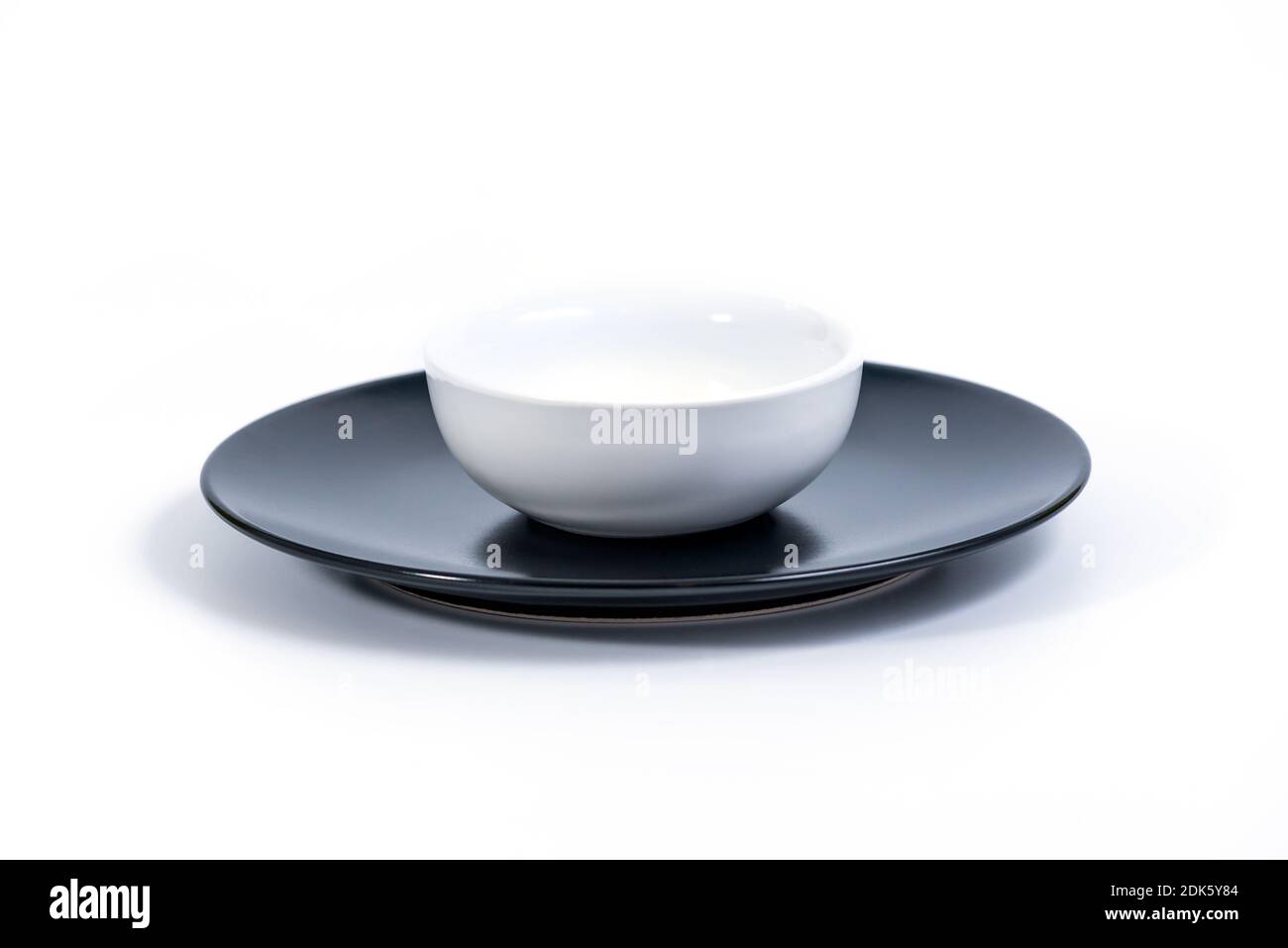 White Bowl in Black Plate isolated on white background, side view Stock