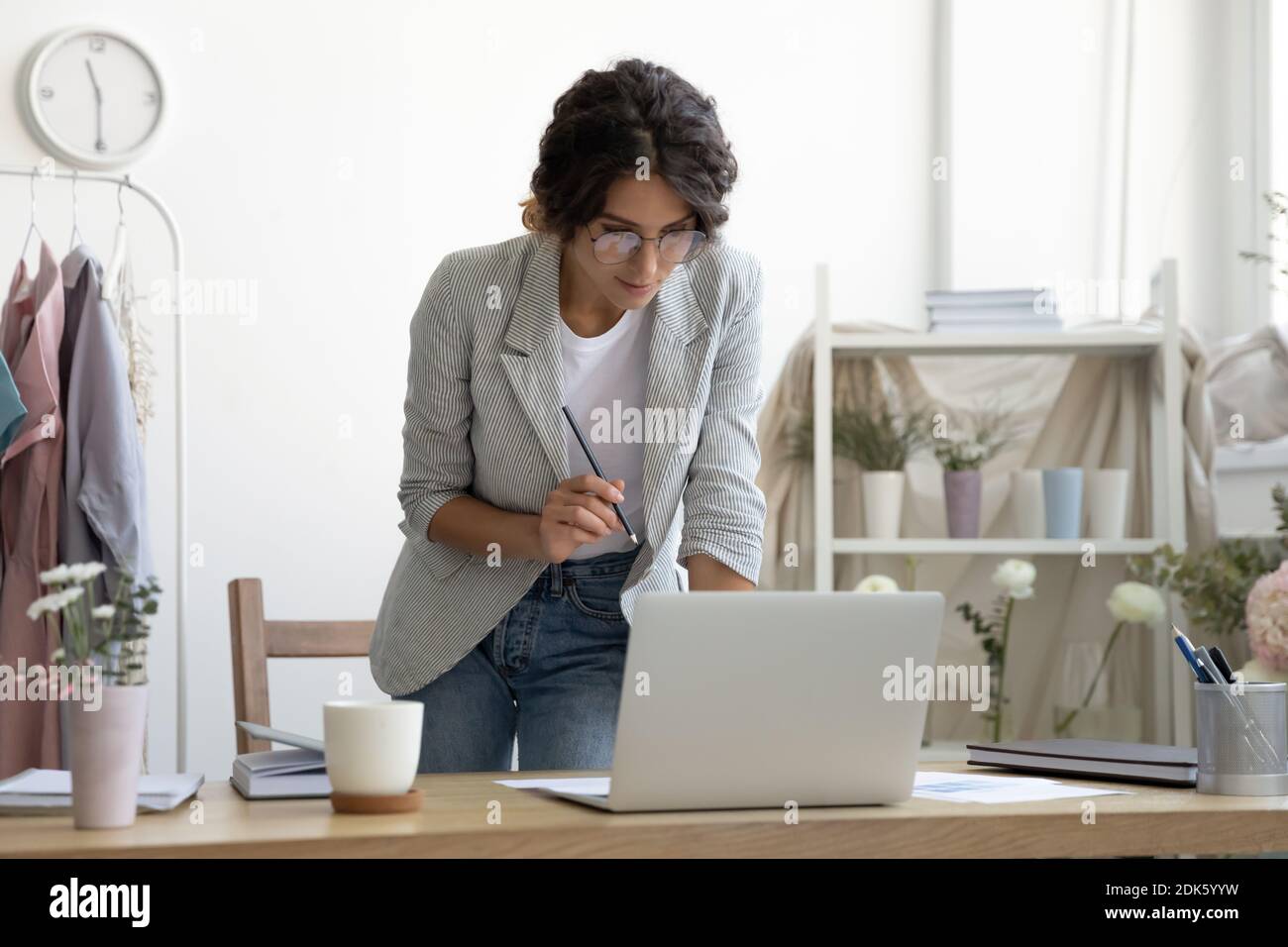 Interested lady designer standing by computer screen creating new sketch Stock Photo