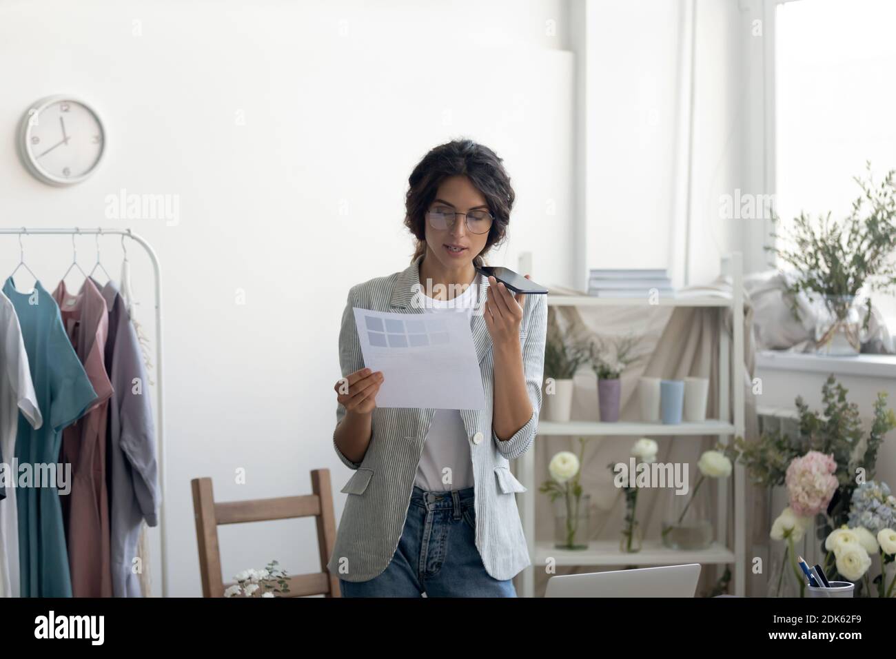 Young lady designer searching information in internet using virtual assistant Stock Photo
