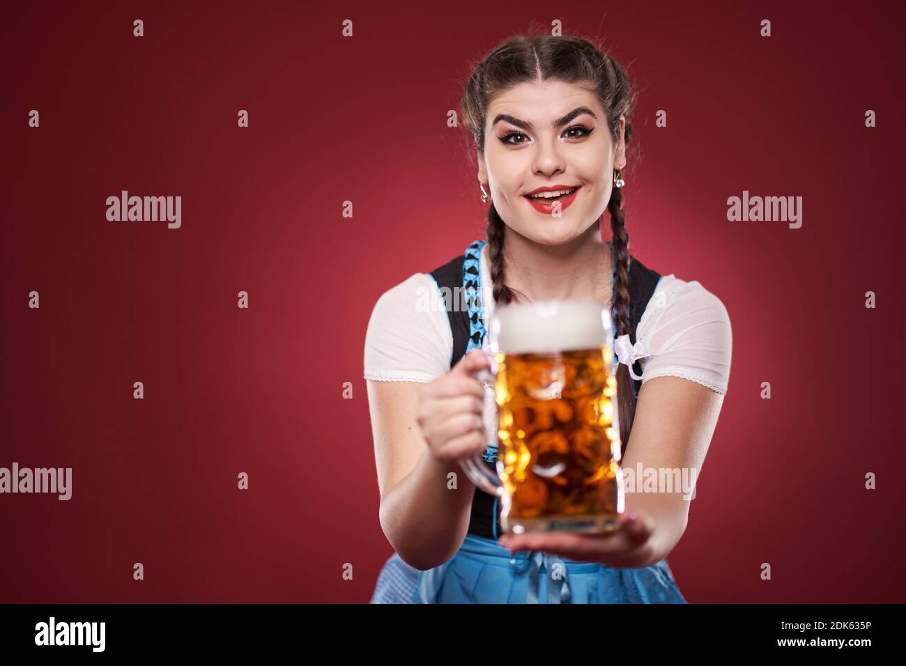 https://c8.alamy.com/comp/2DK635P/young-woman-in-traditional-german-costume-holding-a-pint-of-pale-lager-2DK635P.jpg