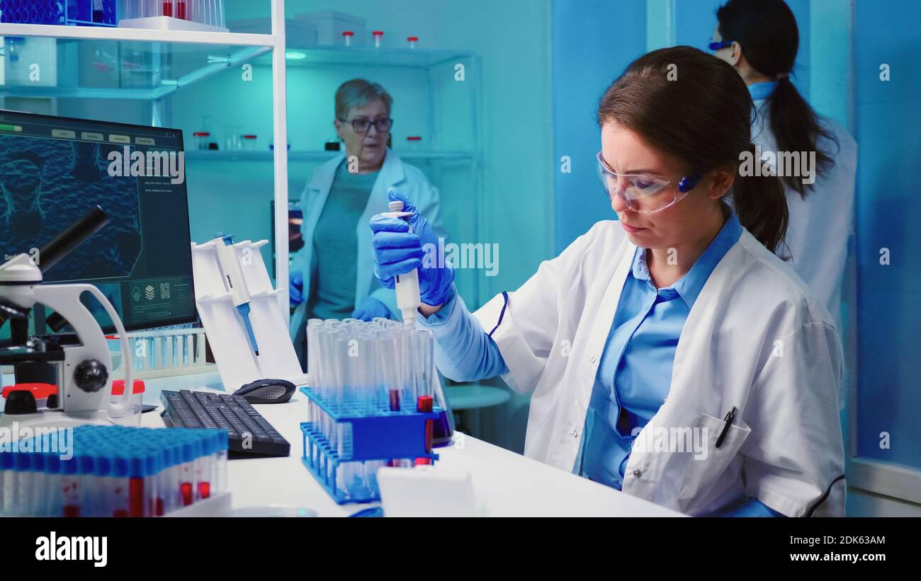 Scientist nurse using micropipette for filling test tubes in modern ...
