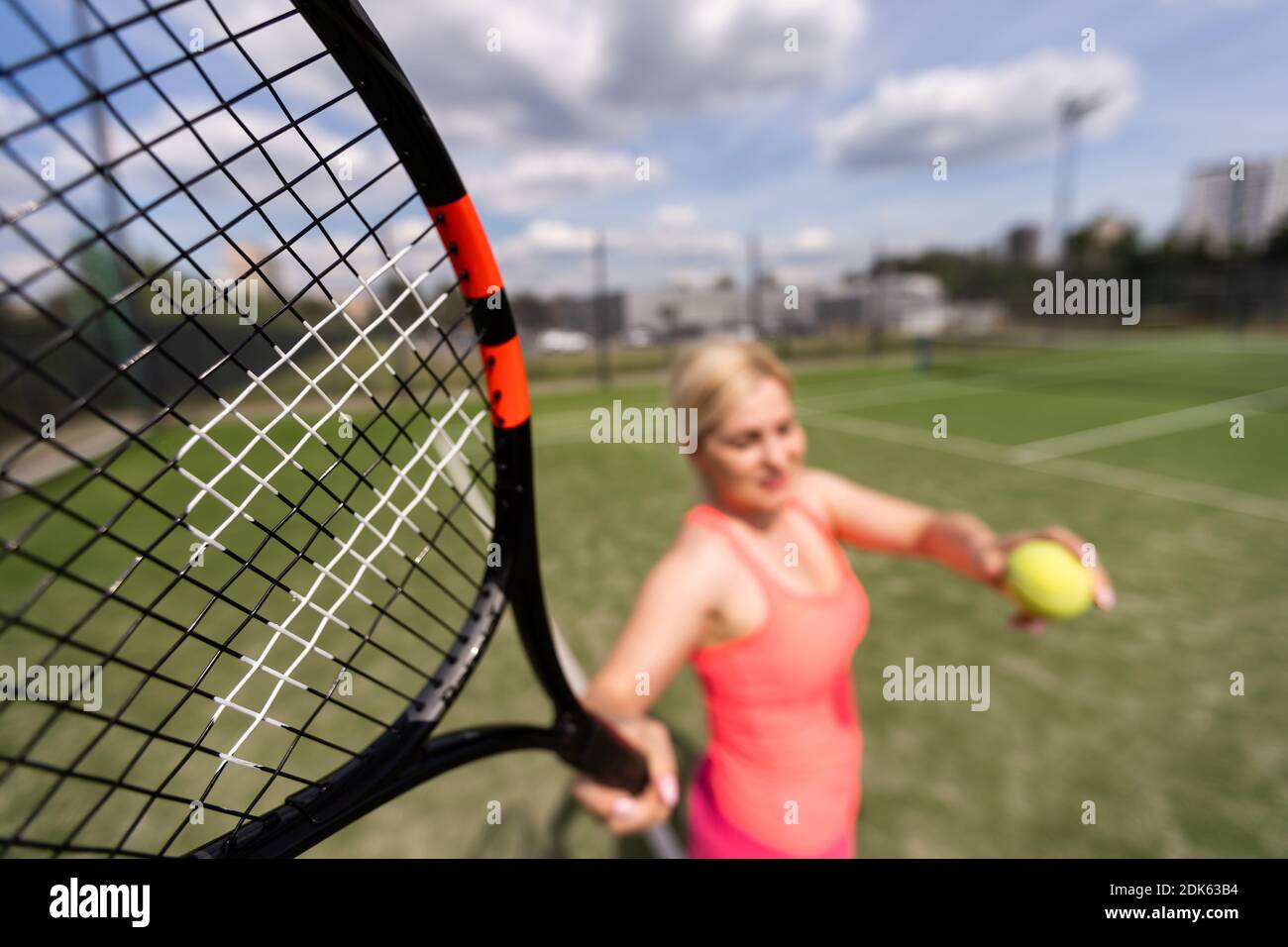 Woman playing tennis holding a racket and smiling Stock Photo - Alamy