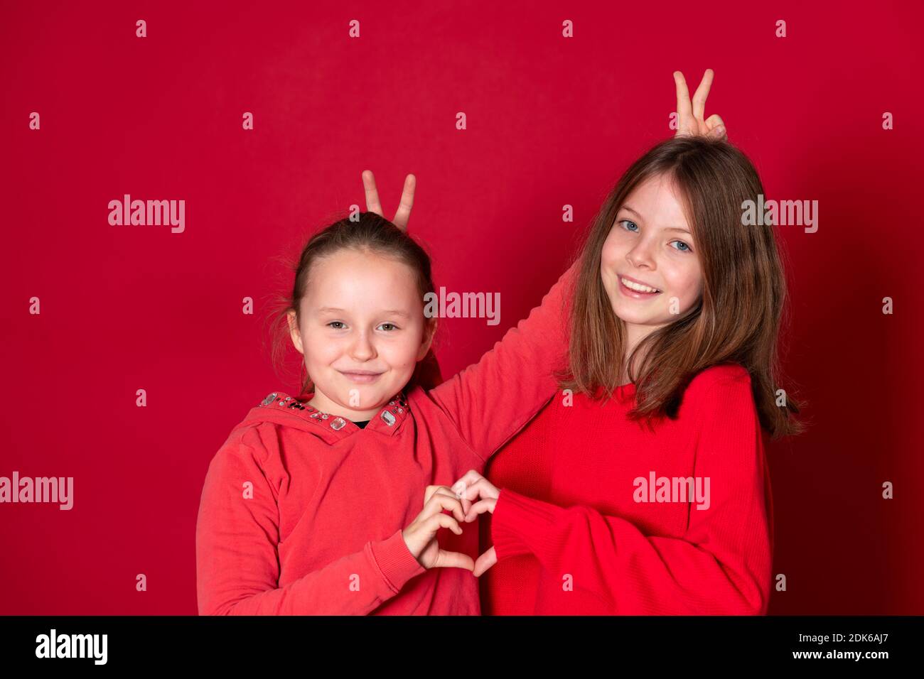 Best Girlfriends Wearing Red Clothes In Front Of Red Background Stock Best Girlfriends Wearing Red Clothes In Front Of Red Background Stock