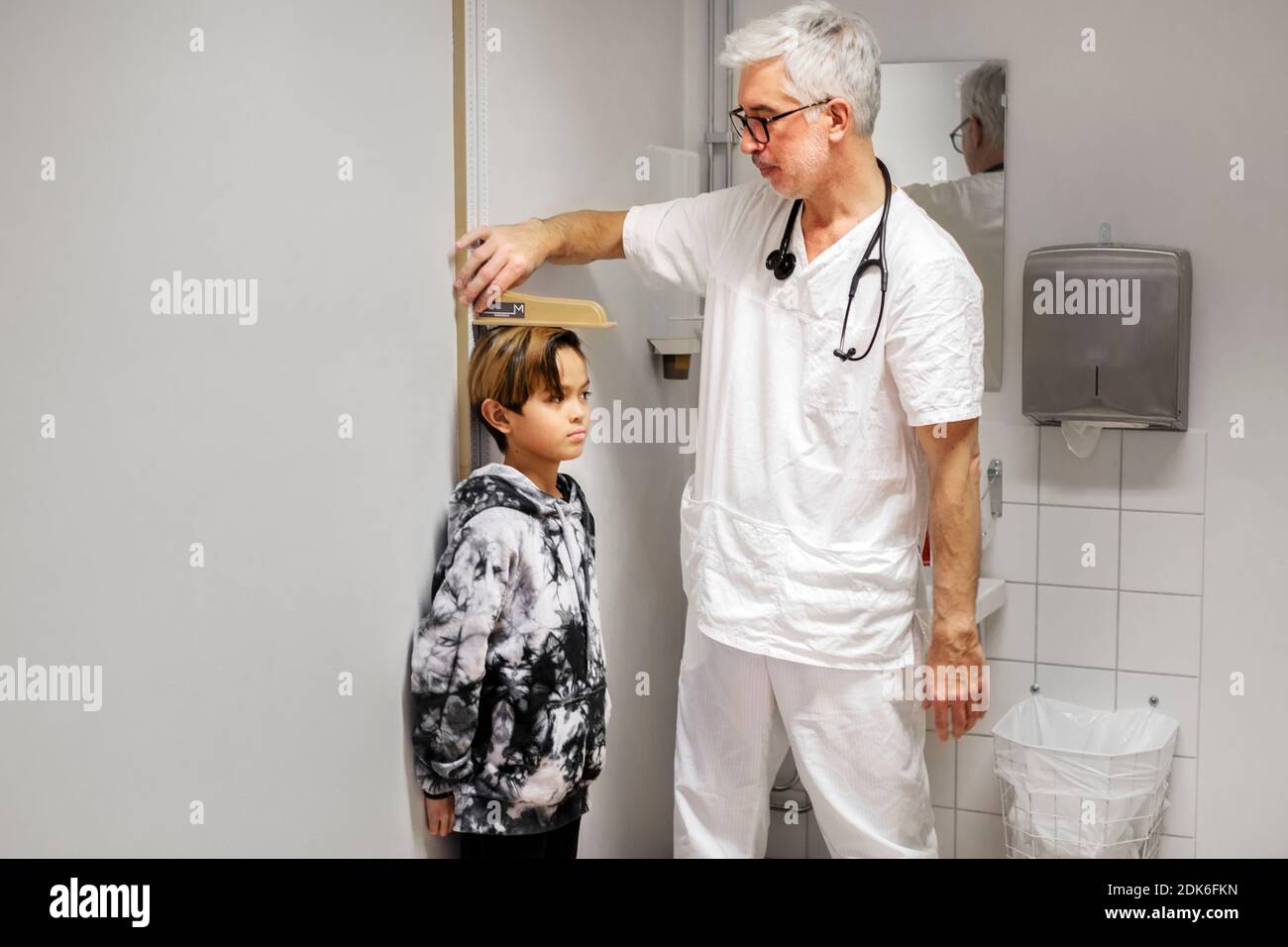 Doctor measuring boy's height Stock Photo