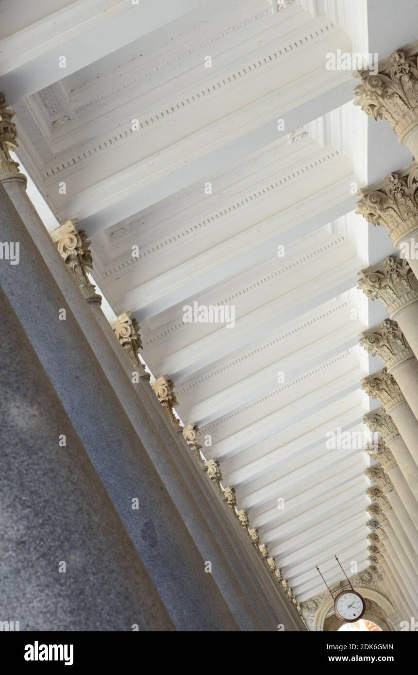 a narrow corridor surrounded by ornate columns Stock Photo