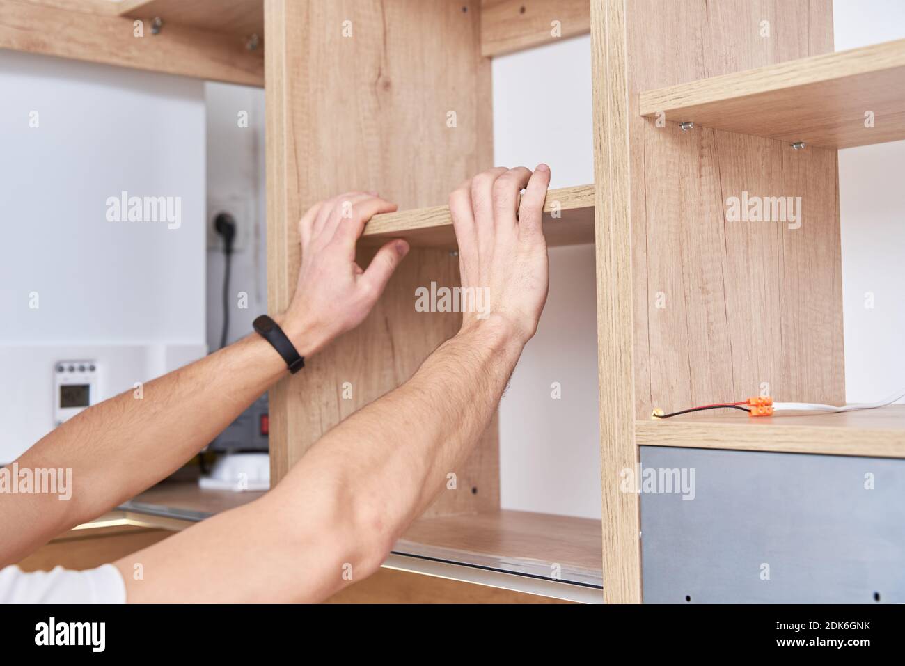 Male carpenter install shelf in the kitchen Stock Photo Alamy