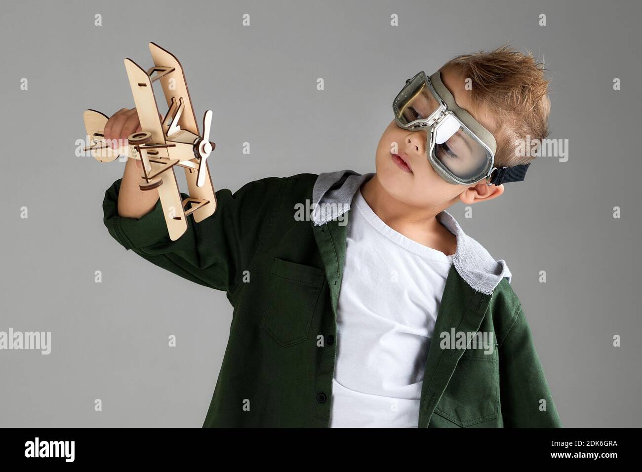 happy child boy in retro glasses playing with wooden toy airplane on ...