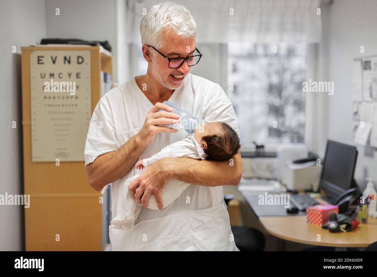 Doctor feeding newborn baby Stock Photo