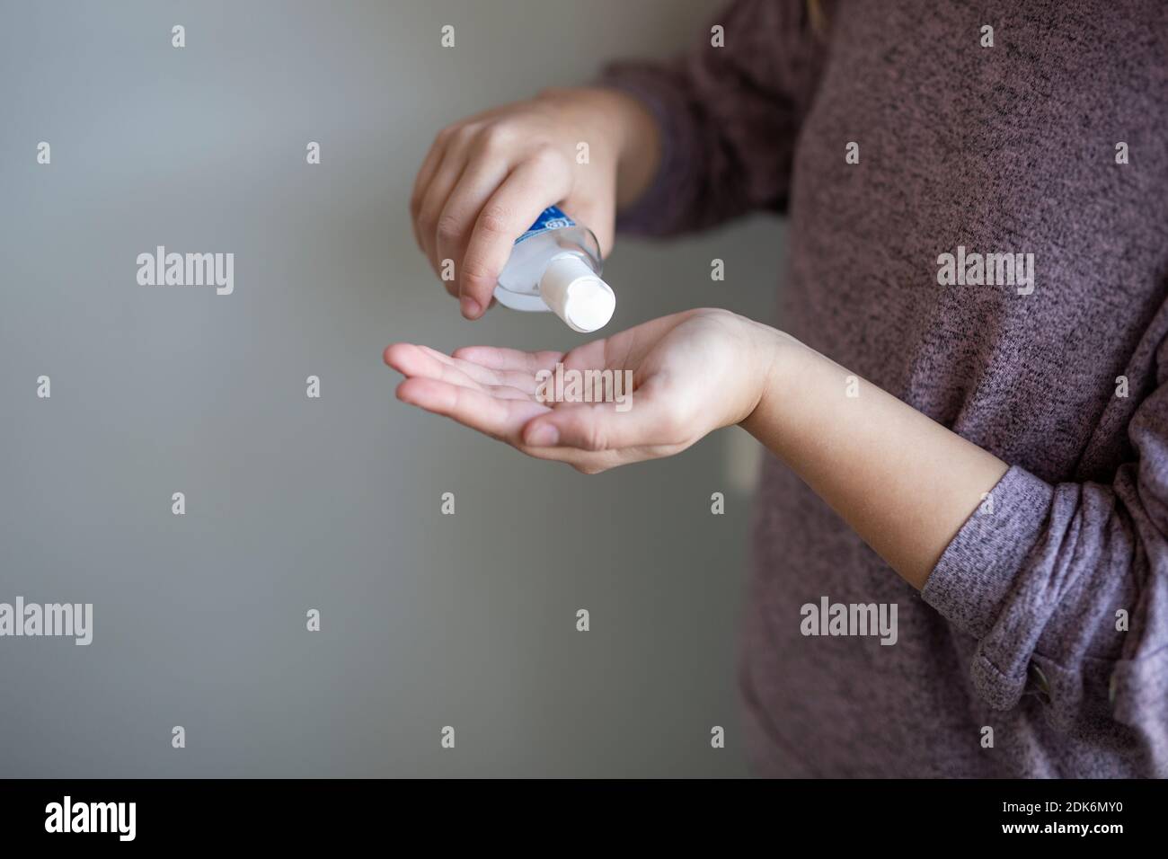 Woman puts hand alcohol on her hands Stock Photo - Alamy