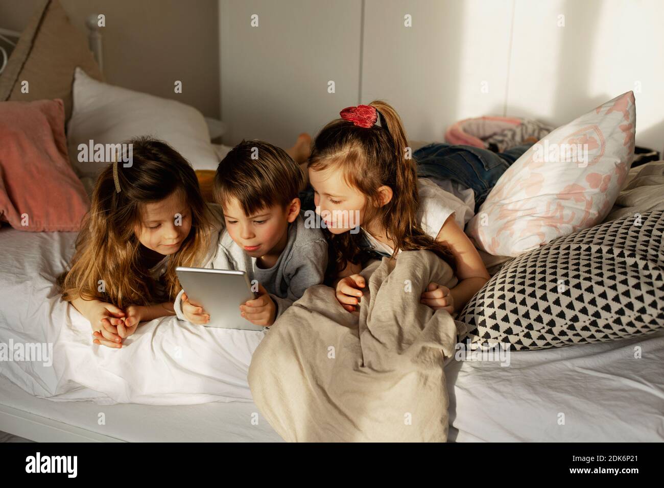 Children On Bed Using Digital Tablet Stock Photo Alamy