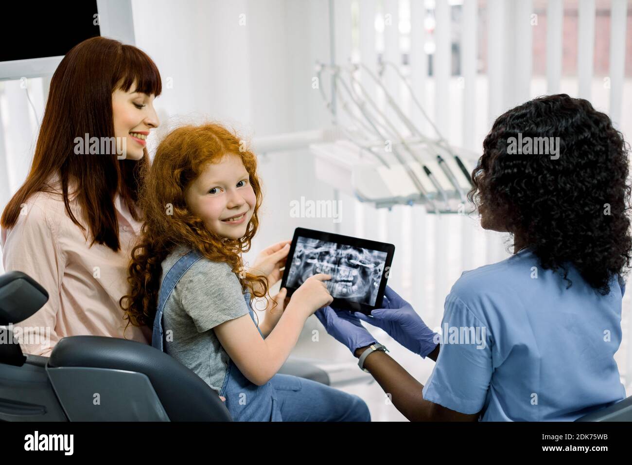 Back view of mother and child girl at appointment with female black