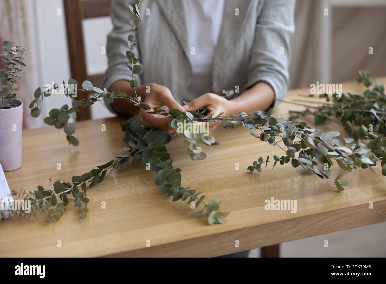 Hands of female flower arranger creating composition of fresh plants Stock Photo