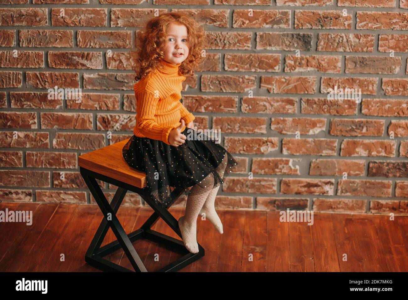 cute little girl sitting on a chair in a new living room Stock Photo ...