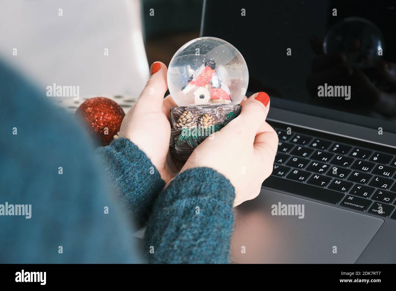 Closeup of Snow Globe Snow Flakes and birds in hands, Beautiful Holiday Concept with Christmas toys. Working at home Stock Photo