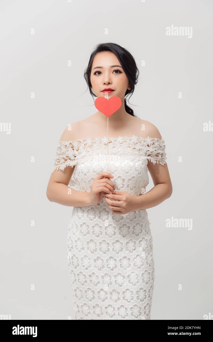 Happy young Asian woman holding love sign over white background Stock ...