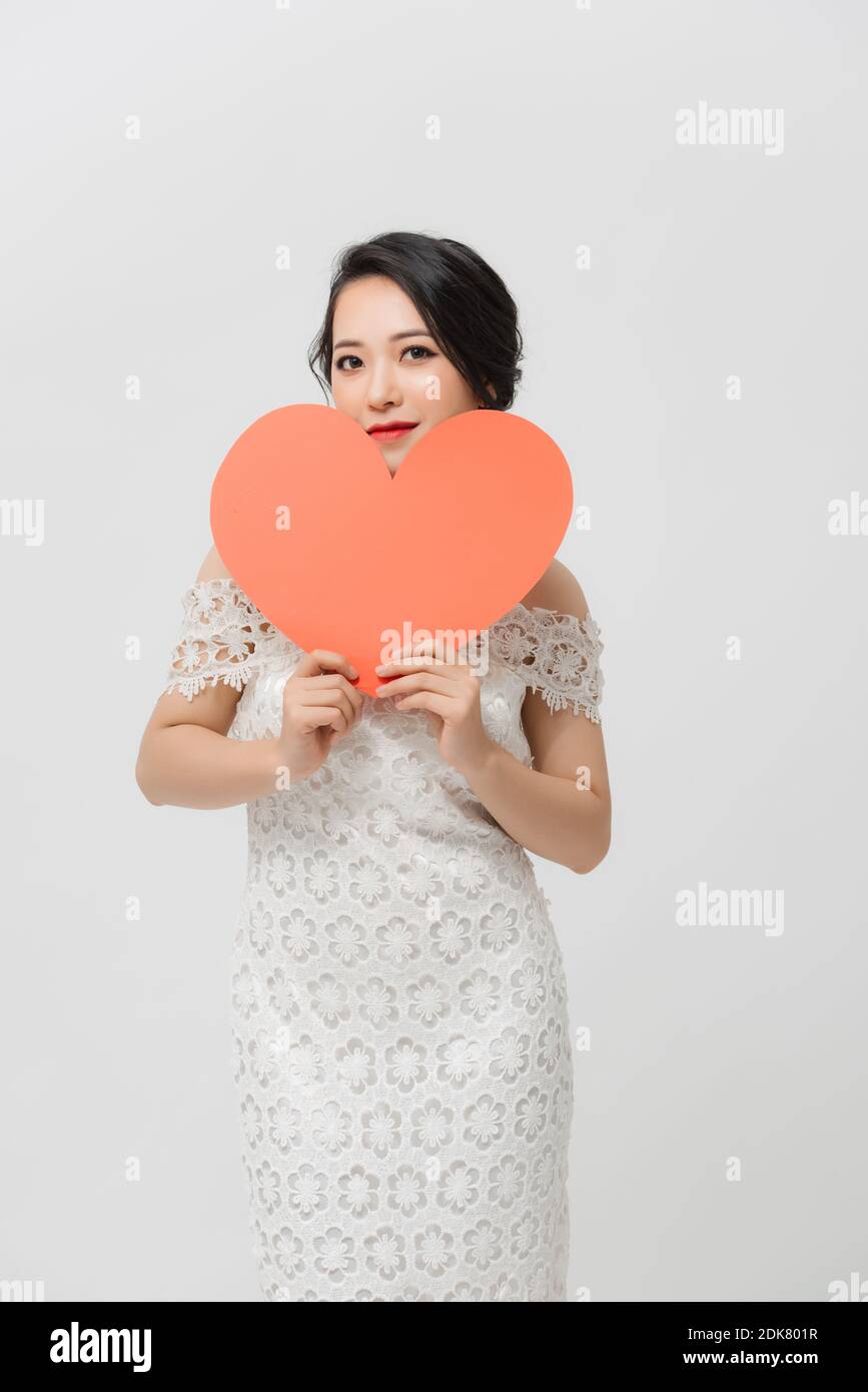 Attractive young Asian woman holding red love shape and standing over ...