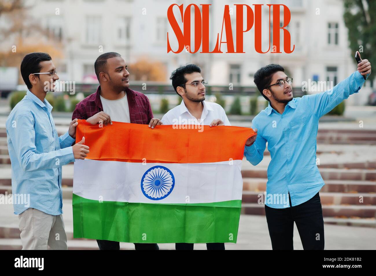 Solapur city inscription. Group of four indian male friends with India flag making selfie on mobile phone. Largest India cities concept. Stock Photo