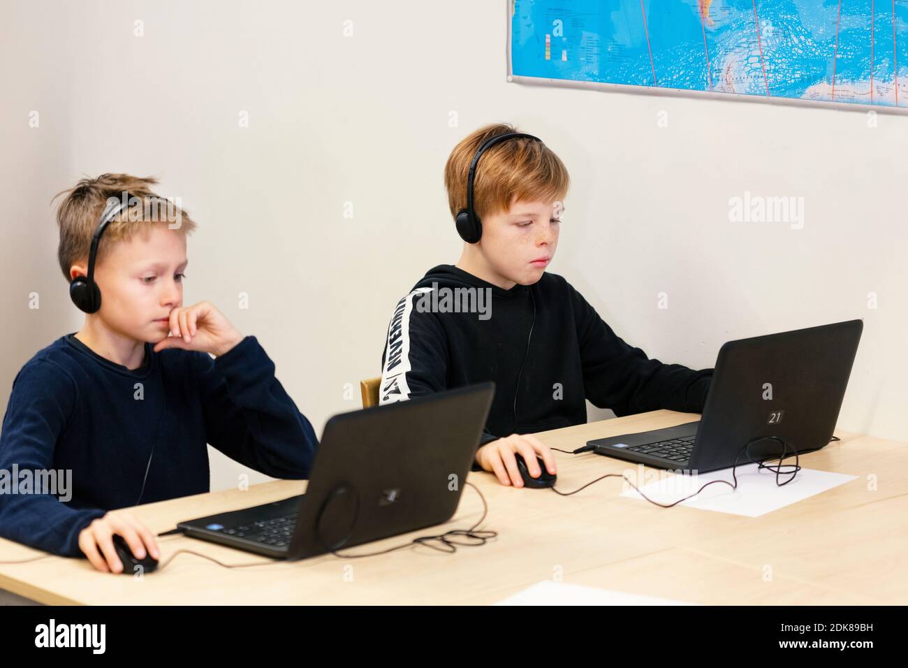 Boys in classroom using laptops Stock Photo