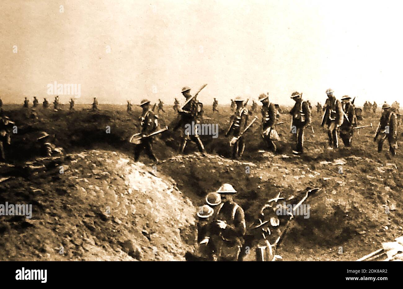 July 1916  WWI . An old press photo of a  'Spade Brigade' digging-party on the Somme - Advancing British soldiers carrying wooden handled, metal spades to create dugouts in the bombed out trenches. Stock Photo