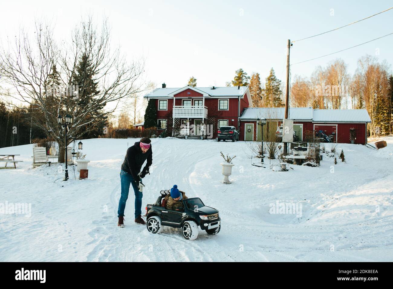 Father looking at daughter in electric toy car Stock Photo - Alamy